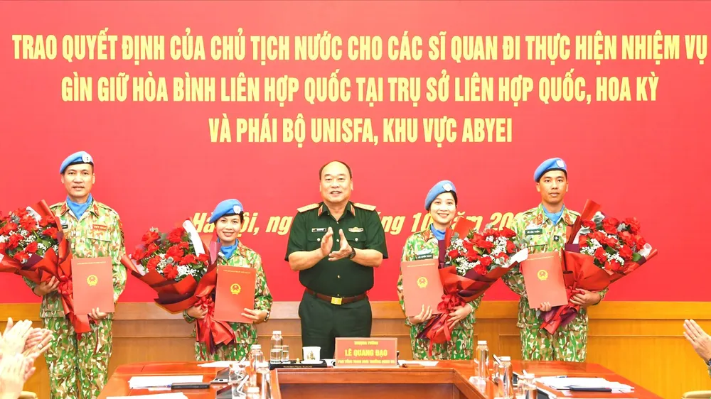 Thượng tướng Lê Quang Đạo trao quyết định và tặng hoa 4 sĩ quan nhận nhiệm vụ. Ảnh: P.S