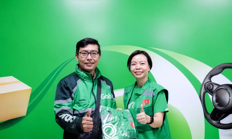 Bà Lý Thụy Bích Huyền, Giám đốc Vận hành, Grab Việt Nam, trao đồng phục tặng các bác tài Grab