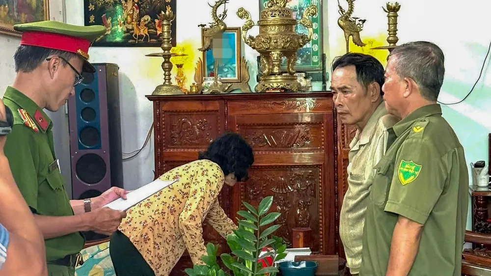 Công an đọc quyết định khởi tố bị can, lệnh bắt tạm giam đối với ông Lê Văn Hoàng. Ảnh: CTV