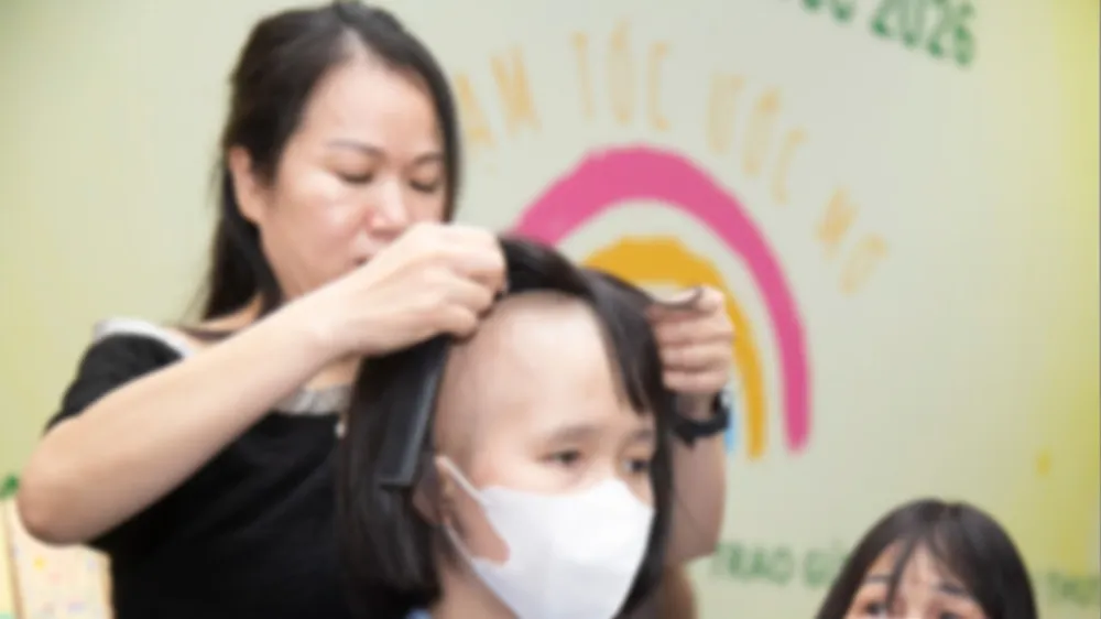 Một bệnh nhân ung thư vui mừng đón nhận mái tóc giả từ chương trình “Trạm tóc ước mơ”. Ảnh: THANH HẰNG