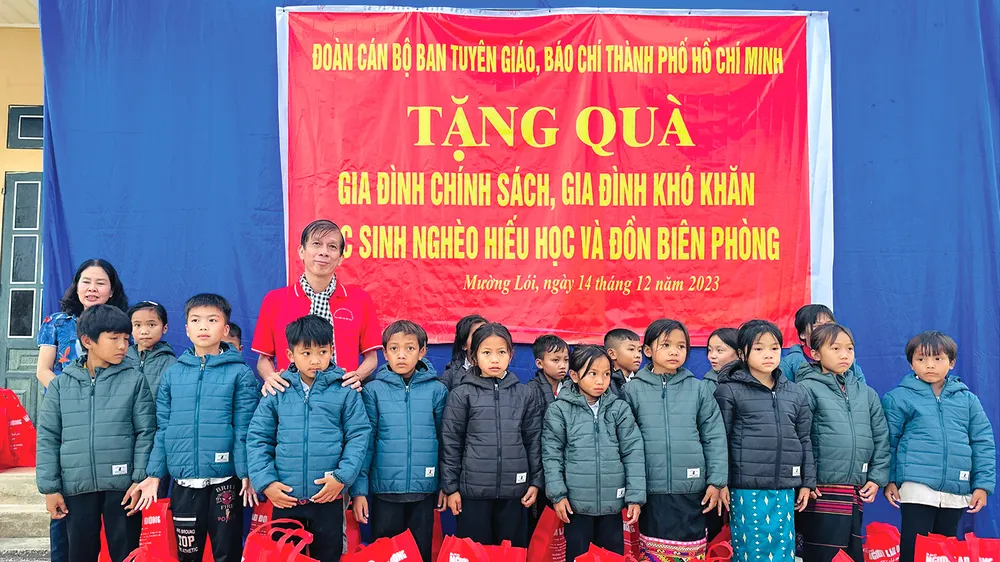 Phó Tổng Biên tập Báo SGGP Nguyễn Khắc Văn trao quà là những chiếc áo ấm trong chương trình “Thắp sáng niềm tin - Vượt khó đến trường” của Báo SGGP đến các em học sinh nghèo hiếu học xã Mường Lói, tỉnh Điện Biên