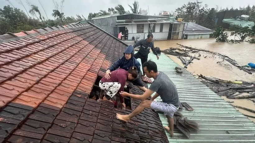 Người dân phải thoát qua mái nhà khi lũ dâng cao. Ảnh: TTXVN