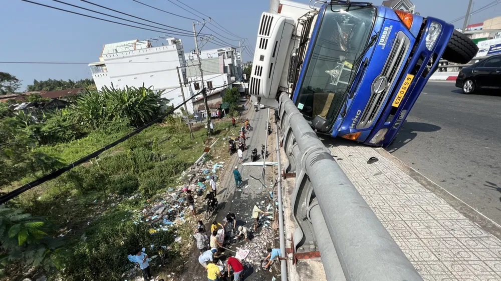 Xe tải lật đè trên lan can cầu Kênh Xáng