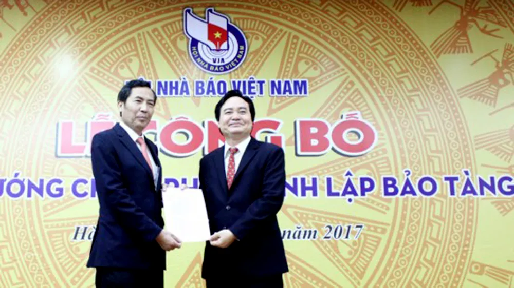 Chủ tịch Hội Nhà báo Việt Nam Thuận Hữu (bên trái) tiếp nhận Quyết định của Thủ tướng Chính phủ về thành lập Bảo tàng Báo chí Việt Nam