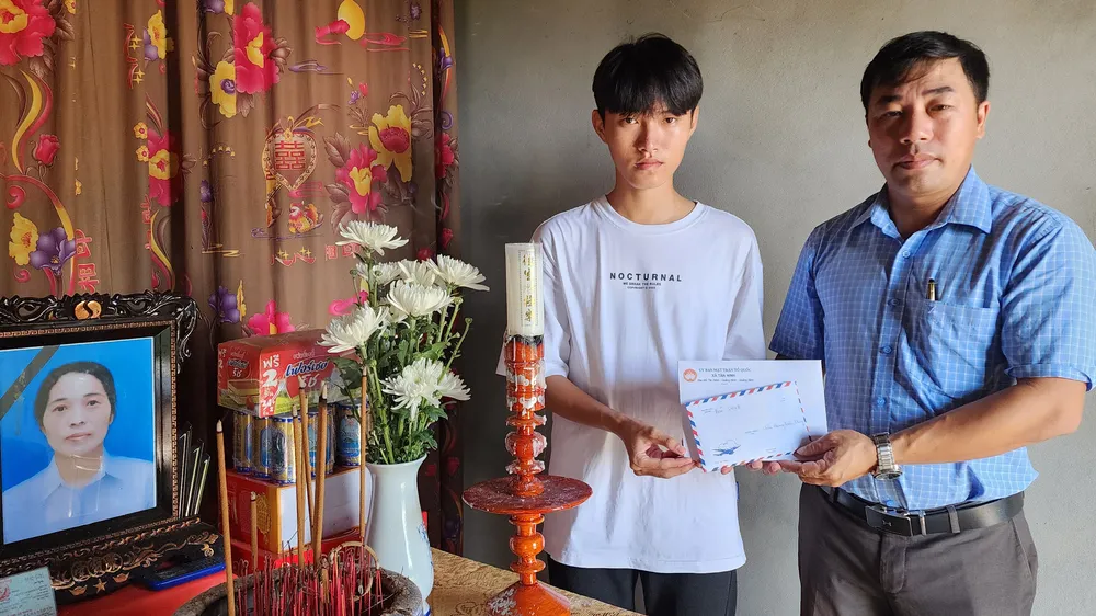 Chủ tịch MTTQVN xã Tân Ninh Nguyễn Duy Hợi trao số tiền 30 triệu đồng của bạn đọc Báo SGGP đến cháu Hoàng Quốc Dương, con trai đầu của chị Hoạt 