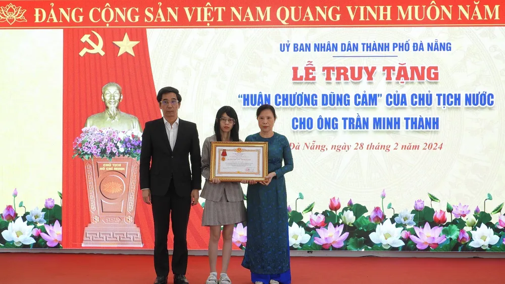 Thừa uỷ quyền của Chủ tịch nước, Phó Chủ tịch TP Đà Nẵng Trần Chí Cường truy tặng Huân chương Dũng cảm cho vợ và con gái ông Thành. Ảnh: DOÃN HÙNG