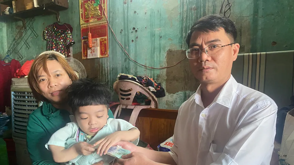 Nhà báo Nguyễn Hùng, Trưởng đại diện Báo SGGP tại miền Trung trao 10 triệu đồng hỗ trợ cháu Nguyễn Võ Chí Tài