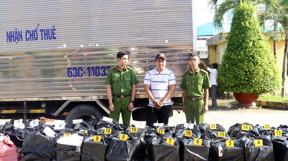 Đối tượng Thiện cùng tang vật hơn 20.000 bao thuốc lá lậu. Ảnh: TUẤN QUANG