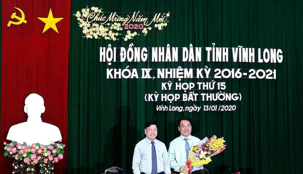 Ông Trần Văn Rón, Bí thư Tỉnh ủy Vĩnh Long (bên trái), tặng hoa chúc mừng ông Lữ Quang Ngời. Ảnh: PHAN THANH
