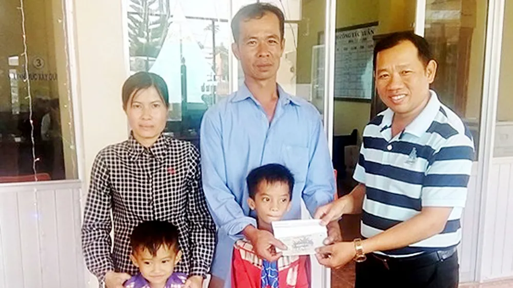 Đại diện Báo SGGP (bên phải) trao 16,7 triệu đồng của bạn đọc Báo SGGP hỗ trợ gia đình chị Thu Vân để có điều kiện trị bệnh và đón tết 