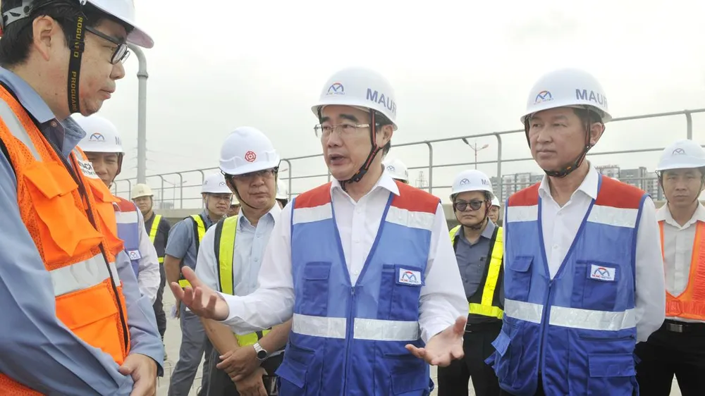Bí thư Thành ủy TPHCM Nguyễn Thiện Nhân trao đổi cùng đại diện nhà thầu tại buổi thị sát ở ga nổi Phước Long. Ảnh: CAO THĂNG