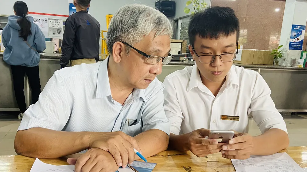 Nhân viên Bưu điện TPHCM hỗ trợ người dân cài đặt ứng dụng VssID.