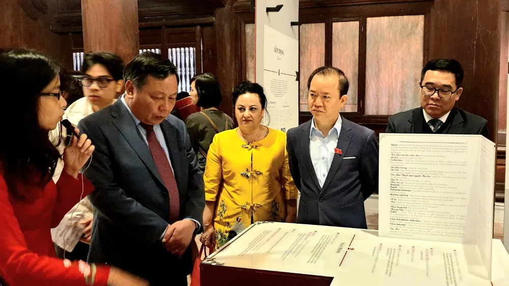 Các đại biểu lắng nghe câu chuyện kể về sự hồi sinh của di sản Văn Miếu tại triển lãm 