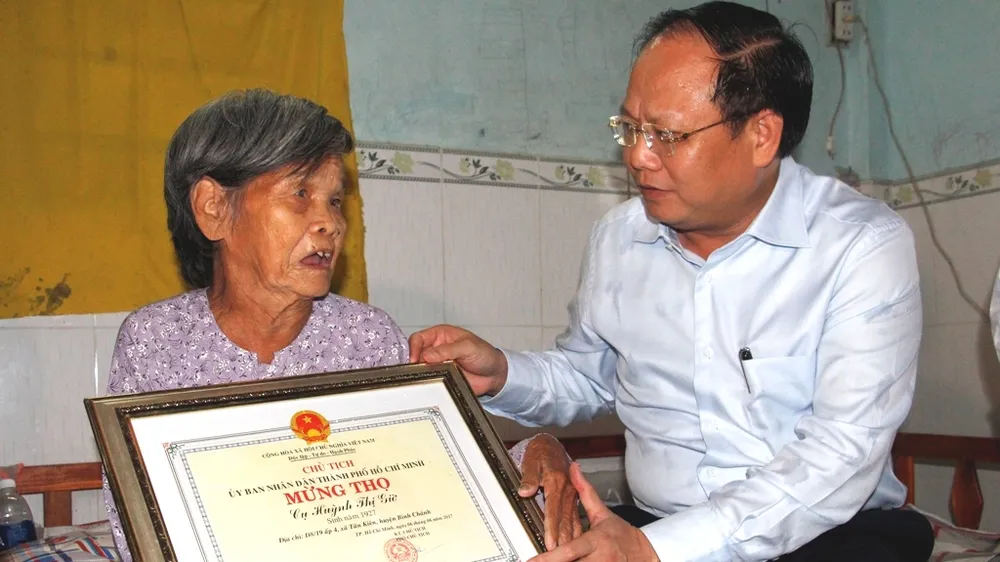 Phó Bí thư Thường trực Thành ủy TPHCM Tất Thành Cang mừng thọ cụ Huỳnh Thị Giờ. Ảnh: TUẤN VŨ