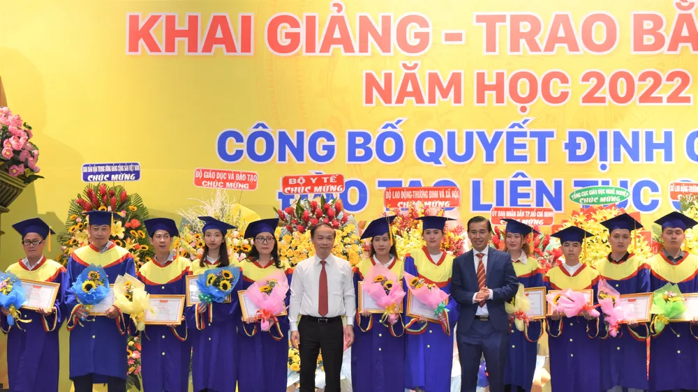 Ông Phạm Tất Thắng, Phó trưởng ban Thường trực Ban Dân vận Trung ương (áo trắng) và TS Lê Lâm, Hiệu trưởng Trường Cao đẳng Đại Việt Sài Gòn trao giấy khen và hoa cho đại diện 177 sinh viên học tập xuất sắc, học giỏi tốt nghiệp ra trường