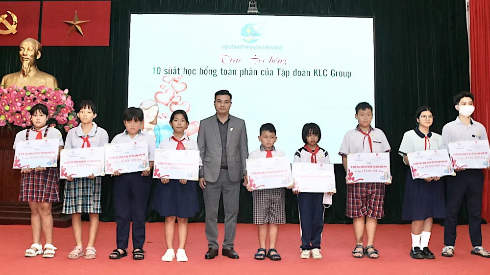 Đại diện doanh nghiệp trao học bổng cho trẻ mồ côi do dịch Covid-19. Ảnh: QUANG HUY