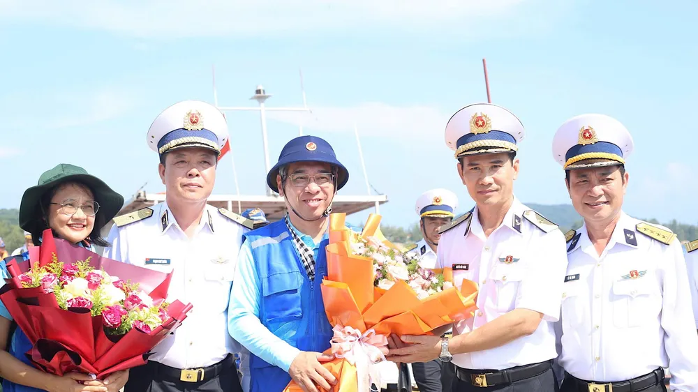 Đồng chí Nguyễn Phước Lộc nhận hoa chào đón Đoàn đại biểu từ Chuẩn Đô đốc Nguyễn Hữu Thoan, Chính ủy Vùng 5 Hải quân. Ảnh: QUANG HUY
