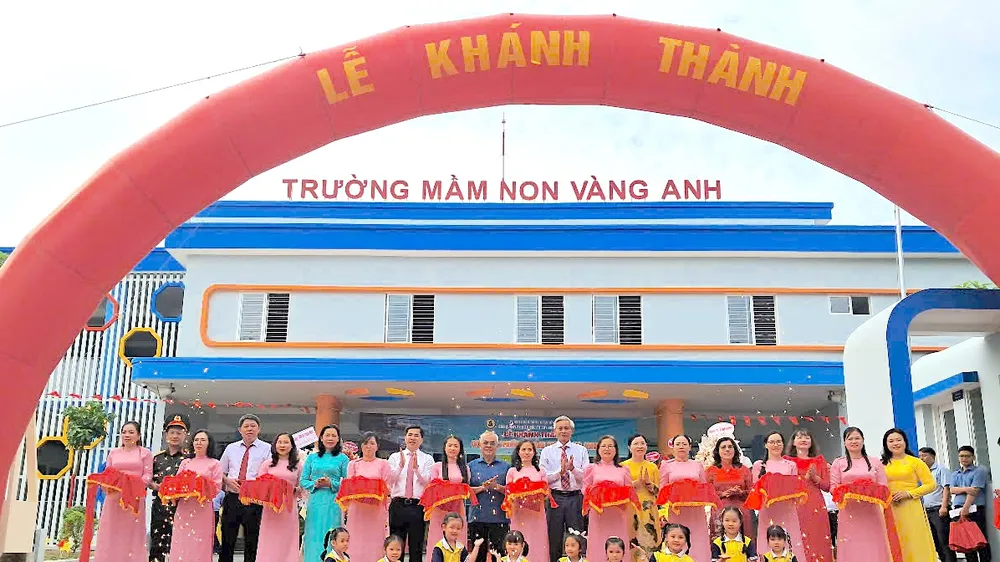 Lãnh đạo huyện Nhà Bè, chủ đầu tư, đơn vị thi công và đại diện Ban giám hiệu cơ sở 2 Trường Mầm non Vàng Anh cắt băng khánh thành ngôi trường mới. Ảnh: QUANG HUY