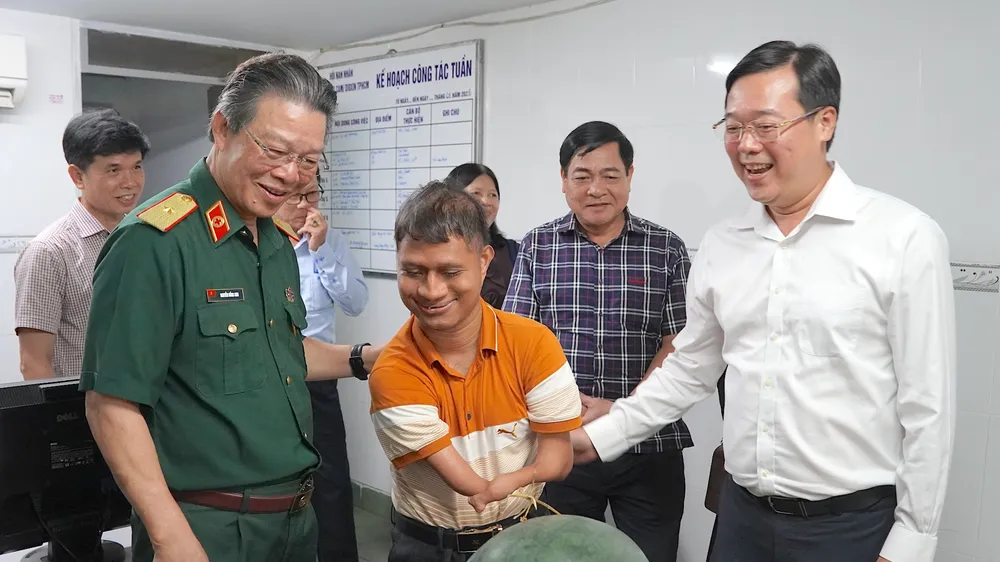 Đồng chí Lê Quốc Phong (ngoài cùng bên phải) cùng PGS-TS-BS Nguyễn Hồng Sơn thăm hỏi bạn trẻ tại Hội nạn nhân chất độc da cam/dioxin TPHCM. Ảnh: QUANG HUY