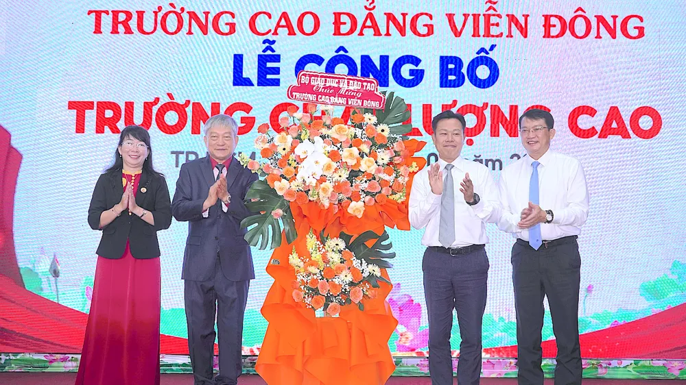 GS.TS Lê Quân, Thứ trưởng Bộ GD-ĐT (thứ 2 từ phải vào) tặng hoa chúc mừng nhà trường. ẢNH QUANG HUY