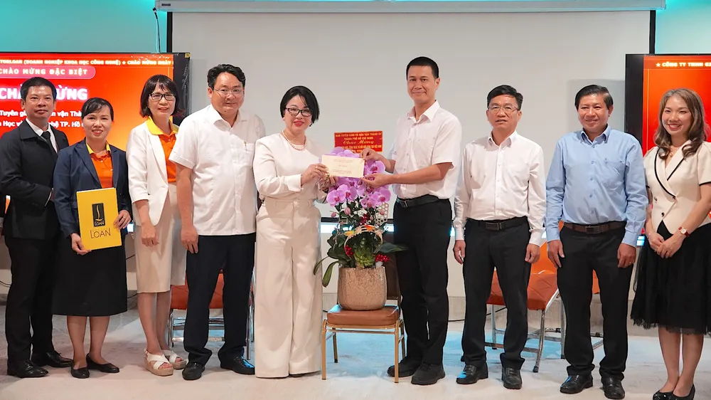Đồng chí Nguyễn Việt Long (thứ 4 từ phải vào) trao quà của thành phố tới bác sĩ Phạm Thị Kim Loan. ẢNH QUANG HUY