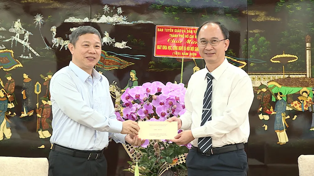 Đồng chí Dương Anh Đức chúc mừng PGS.TS Trần Cao Vinh. ẢNH QUANG HUY