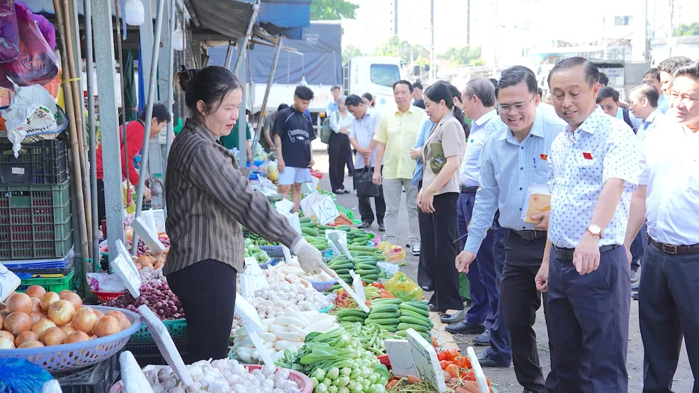 Đồng chí Huỳnh Thanh Nhân, Phó Chủ tịch HĐND TPHCM (thứ 2 từ phải vào) khảo sát việc bảo đảm ATTP tại chợ nông sản Thủ Đức. QUANG HUY