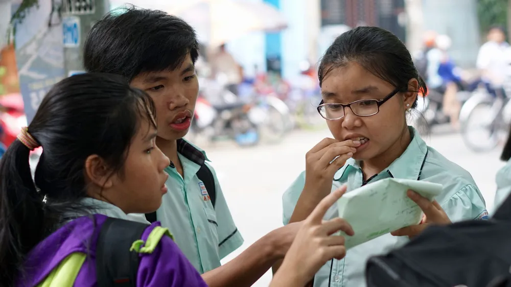 Thí sinh bàn luận sau khi kết thúc môn thi tiếng Anh tại hội đồng thi Nguyễn Thị Thập, quận 7. Ảnh: HOÀNG HÙNG