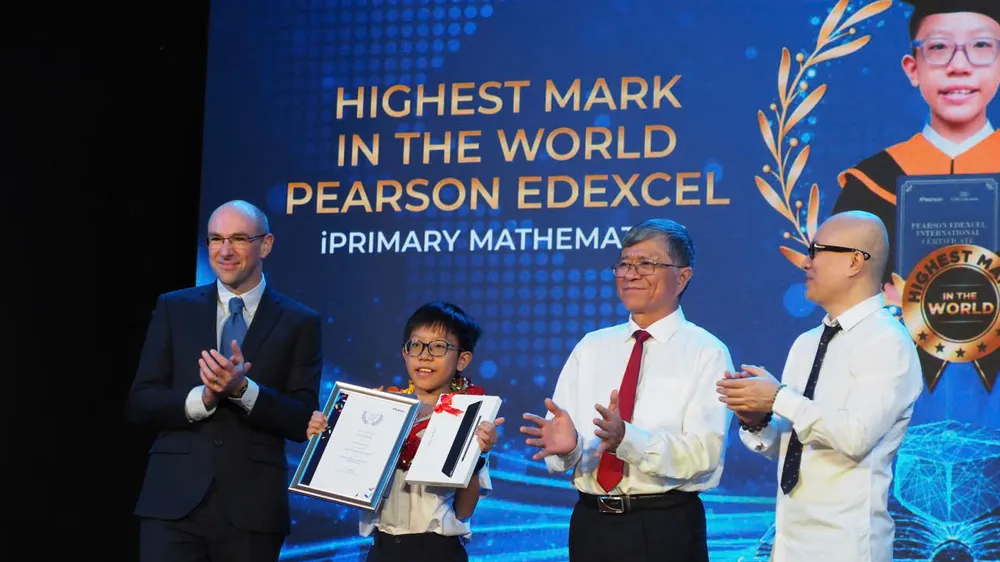 Giám đốc Sở GD-ĐT TPHCM cùng đại diện Hội đồng khảo thí Pearson Edexcel, Tập đoàn giáo dục EMG Education trao thưởng cho học sinh đạt điểm Toán cao nhất thế giới cấp tiểu học
