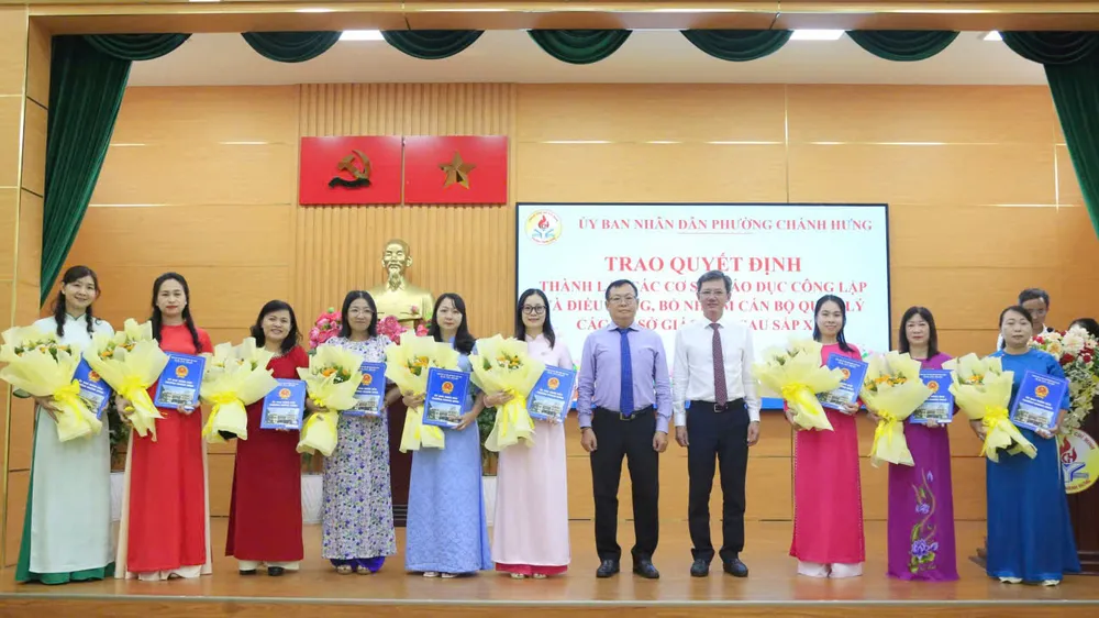 Chủ tịch UBND phường Chánh Hưng Phạm Quang Tú (thứ 7 từ trái sang) trao các quyết định hiệu trưởng, phó hiệu trưởng sau sắp xếp cơ sở giáo dục