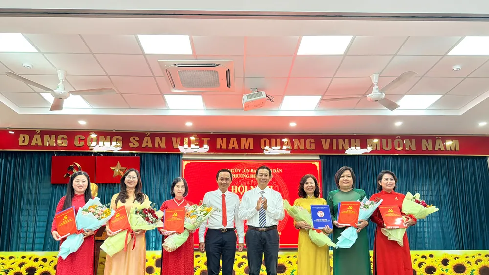 Ông Lương Vũ Ngữ, Phó Bí thư Thường trực Đảng ủy phường Hòa Hưng (thứ tư từ phải qua) trao các quyết định cán bộ sau sắp xếp trường học