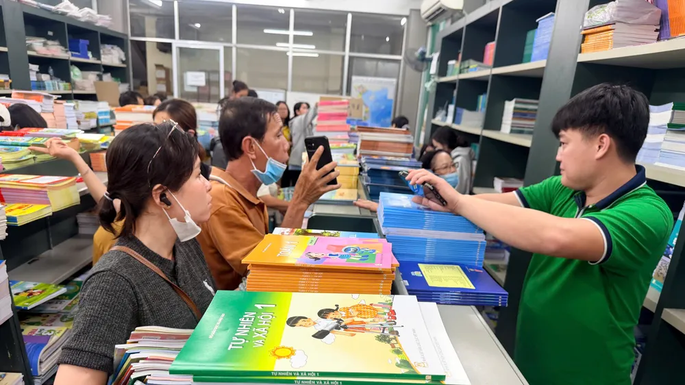 Phụ huynh mua SGK cho con tại trụ sở NXBGDVN tại TPHCM vào trưa 15-9. Ảnh: HOÀNG HÙNG