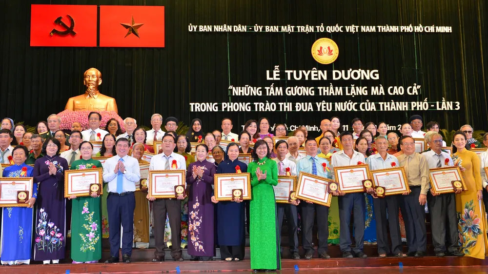 Các đồng chí lãnh đạo TPHCM chúc mừng các tấm gương thầm lặng mà cao cả. Ảnh: VIỆT DŨNG