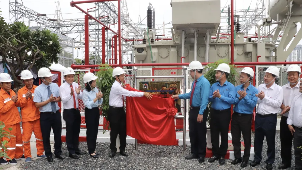 Các đại biểu thực hiện nghi thức gắn biển công trình “Lắp máy biến thế thứ 3 tại trạm 110kV Trường Đua”