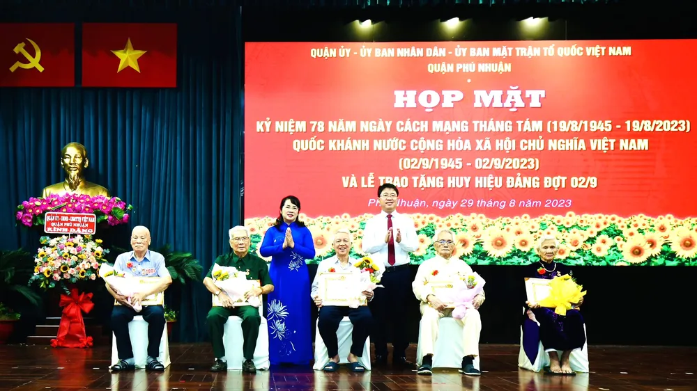 Chủ tịch Ủy ban MTTQ Việt Nam TPHCM Trần Kim Yến chúc mừng các đảng viên cao tuổi Đảng tại quận Phú Nhuận nhận Huy Đảng đợt 2-9. Ảnh: BÙI HẢI