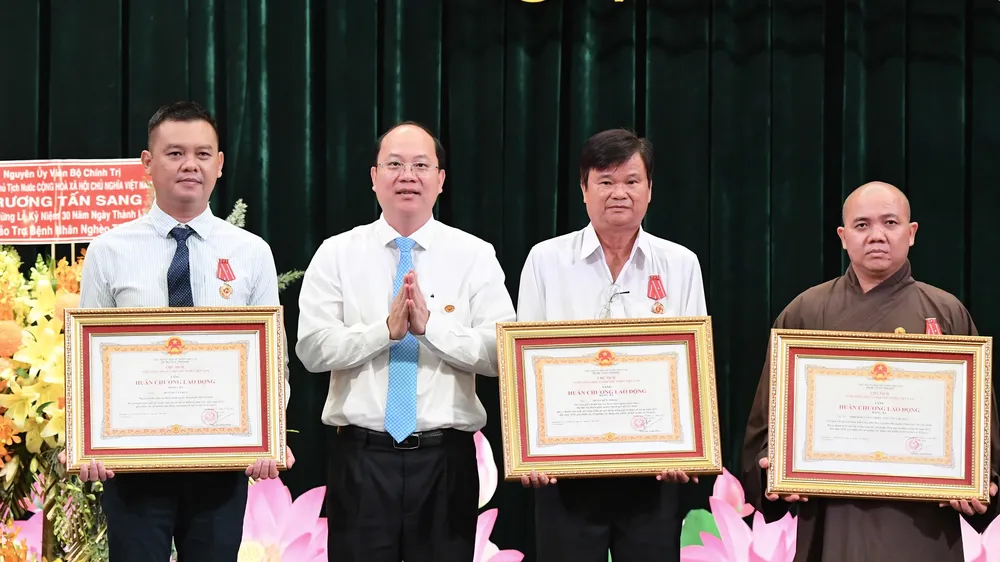 Phó Bí thư Thường trực Thành ủy TPHCM Nguyễn Hồ Hải trao Huân chương Lao động Ba của Chủ tịch nước đến 3 cá nhân. Ảnh: VIỆT DŨNG