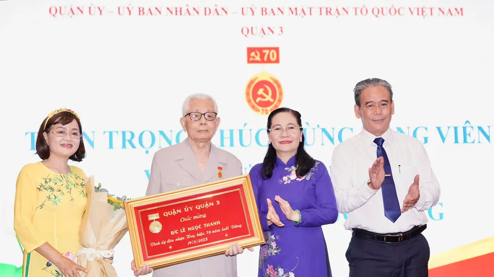 Đồng chí Nguyễn Thị Lệ, Phó Bí thư Thành ủy, Chủ tịch HĐND TPHCM trao Huy hiệu 70 năm tuổi Đảng đến đồng chí Lê Ngọc Thanh. Ảnh HOÀNG HÙNG