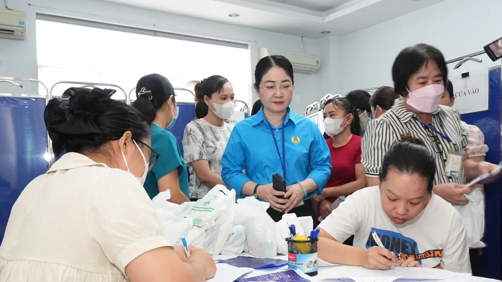 Nữ công nhân điền thông tin để được kiểm tra sức khỏe, tầm soát ung thư tại chương trình