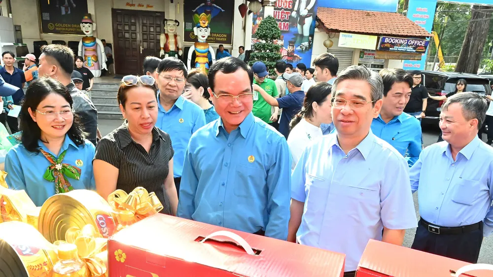 Đồng chí Nguyễn Đình Khang và đồng chí Nguyễn Phước Lộc tham quan gian hàng "Chợ Tết Công đoàn" tại TPHCM. Ảnh: VIỆT DŨNG
