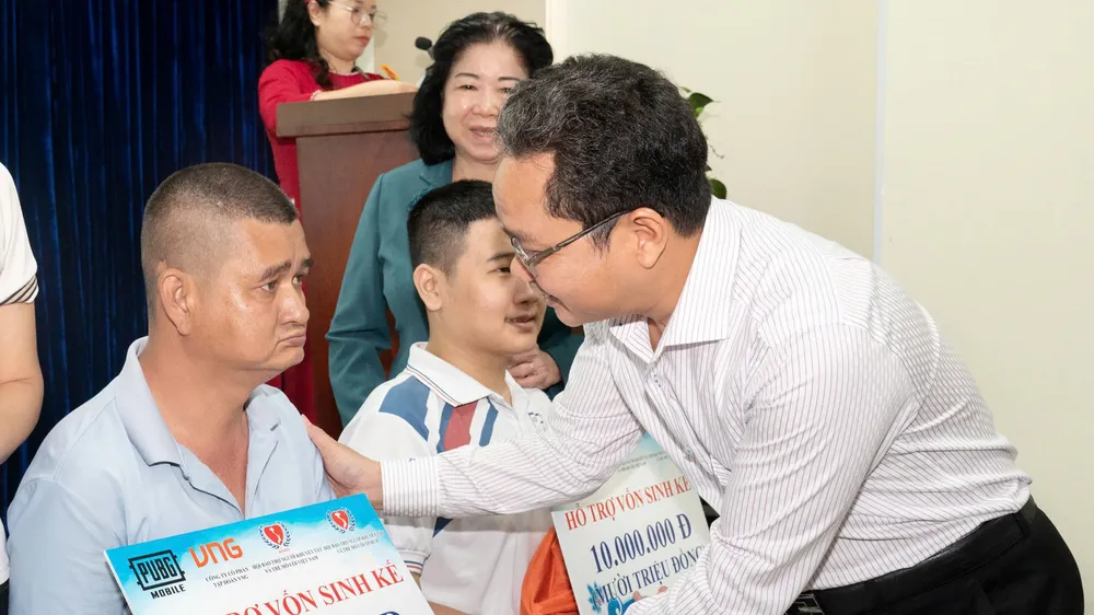 Phó Chủ tịch Ủy ban MTTQ Việt Nam TPHCM Phạm Minh Tuấn trao hỗ trợ sinh kế đến người khuyết tật khó khăn. Ảnh: QUỐC THANH