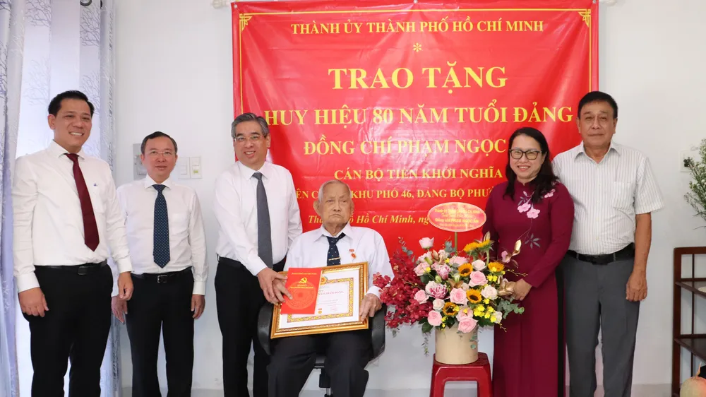 Phó Bí thư Thành ủy TPHCM Nguyễn Phước Lộc trao Huy hiệu 80 năm tuổi Đảng đến đồng chí Phạm Ngọc Ẩn. Ảnh: THÁI PHƯƠNG