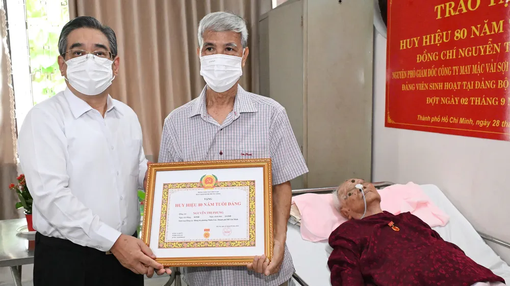 Phó Bí thư Thành ủy TPHCM Nguyễn Phước Lộc trao Huy hiệu 80 năm tuổi Đảng đến đồng chí Nguyễn Thị Phụng (thông qua người thân trong gia đình). Ảnh: VIỆT DŨNG.