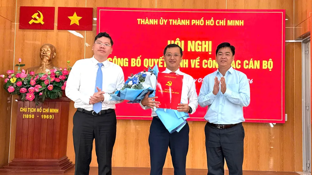 Đồng chí Hoàng Nguyên Dinh và đồng chí Lê Văn Minh trao quyết định, tặng hoa chúc mừng đồng chí Tạ Quốc Trung. Ảnh: THÁI PHƯƠNG