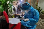 Nhân viên y tế chuẩn bị lấy mẫu xét nghiệm cho người dân