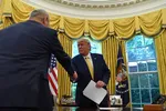 Chinese Vice Premier Liu He (L) hands over a letter of Chinese leader Xi Jinping to President Donald Trump at the Oval Office of the White House in Washington, on Oct. 11, 2019 (NICHOLAS KAMM/AFP via Getty Images)