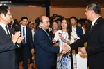 Prime Minister Nguyen Xuan Phuc talks with delegates attending the Conference in 2018.