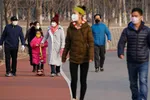 People wearing masks walk at a park in Beijing on Feb. 29, 2020. (Lintao Zhang/Getty Images)