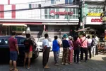 Người dân xếp hàng trước một chi nhánh ngân hàng ở Yangon để chờ rút tiền. Ảnh: Reuters.