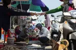 A vendor hands money to a motorist as people buy seafood at the Duong Dong market in Phu Quoc, Vietnam. Photographer: Maika Elan/Bloomberg , Bloomberg