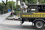 Phun thuốc khử trùng trên đường phố ở Hà Nội - Ảnh: Reuters